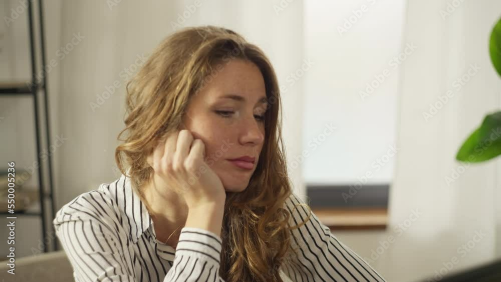 Caucasian woman is bored at the workplace at the computer. Not interesting and hard work in the home office. The sad girl leans on her arm and falls asleep at the table. High quality 4k footage Caucasian woman is bored at the workplace at the computer. Not interesting and hard work in the home office. The sad girl leans on her arm and falls asleep at the table. High quality 4k footage