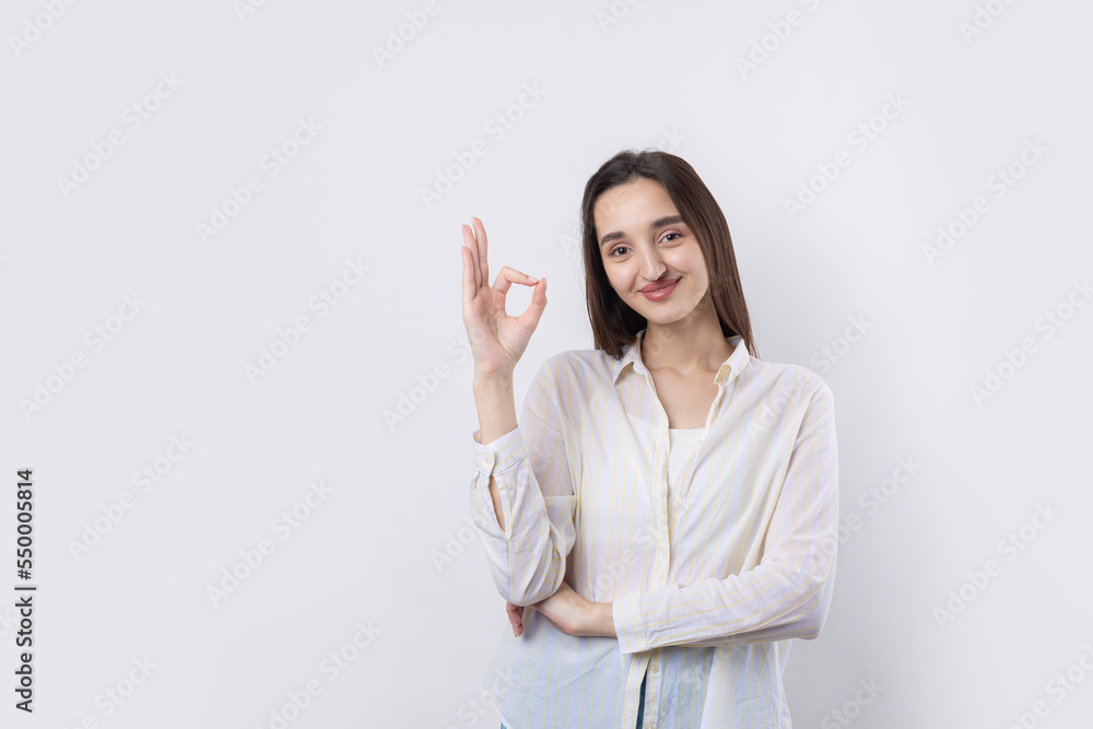 Smiling girl gesturing OK sign with her hand Smiling girl gesturing OK sign with her hand