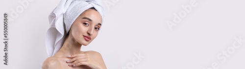 Beautiful girl with thick eyebrows and perfect skin at white background  towel on head  beauty photo.