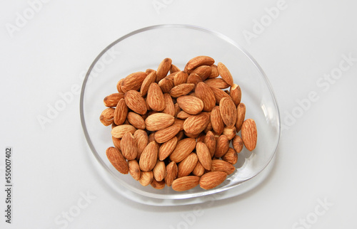 small grains of natural dry brown almonds in a decorative plate
