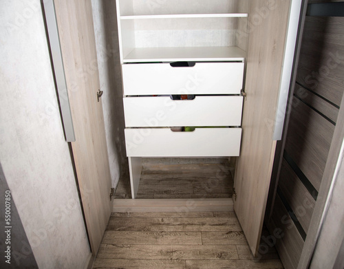 Modern closet in the hallway with hinged doors and pull-out shelves. Production of furniture under the order. photo