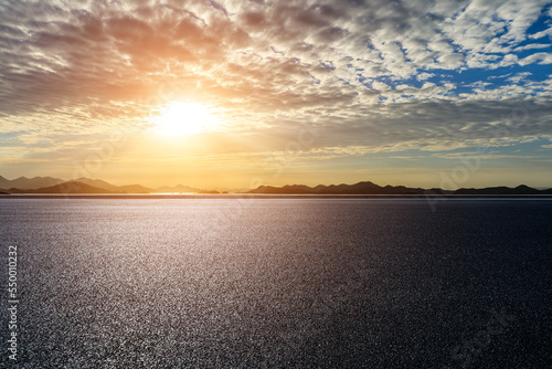 Asphalt road and sea with mountain nature background at sunrise