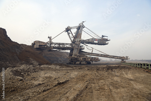 Bucket-wheel excavator during excavation at the surface mine. Huge excavator on open pit mine.