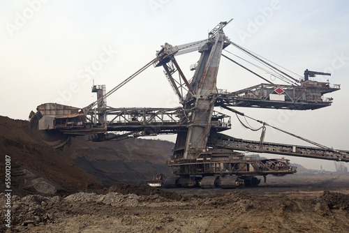 Bucket-wheel excavator during excavation at the surface mine. Huge excavator on open pit mine.