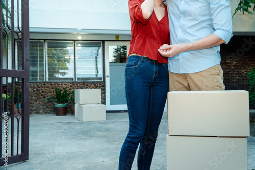 Man comforting his wife and woman hugging her husband and cry in front of the house and full of cardboard boxes during the transport in move out day, moving home concept