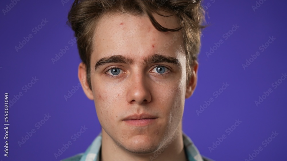 Fototapeta premium Closeup portrait of smiling happy young hipster man 20s isolated on solid purple background with copy space in studio