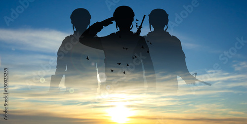 Military silhouettes of soldiers against the sunset or sunrise. Concept for Armed Forces Day.