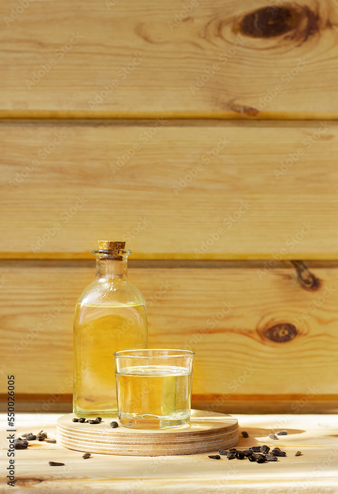 Sunflower oil in a bottle glass with seeds on wooden background Sunflower oil in a bottle glass with seeds on wooden background