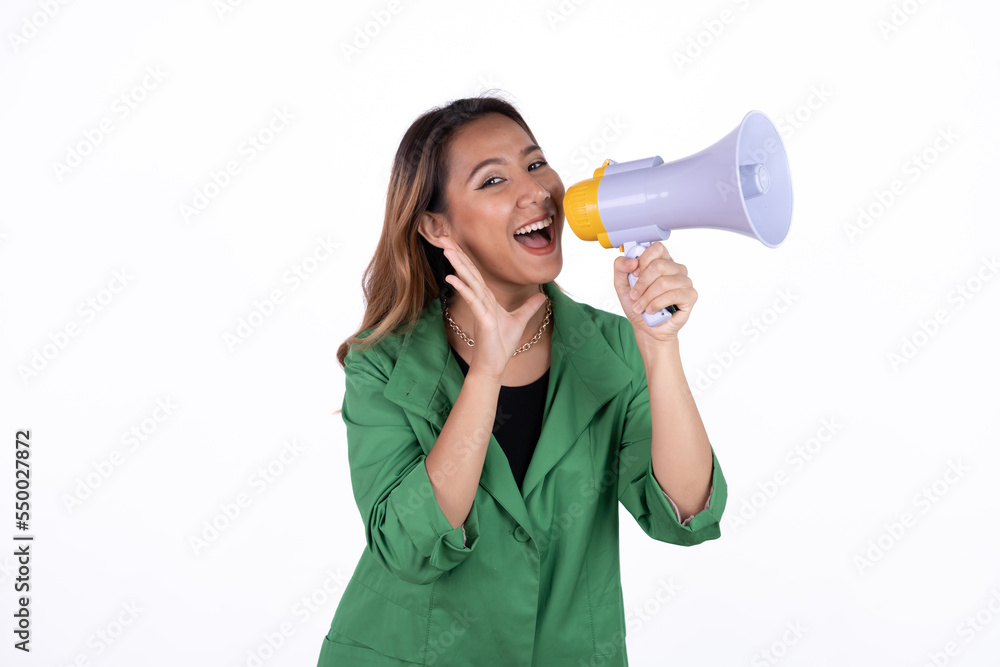 Young asian woman shouts into a megaphone. Isolated white background. Young asian woman shouts into a megaphone. Isolated white background.