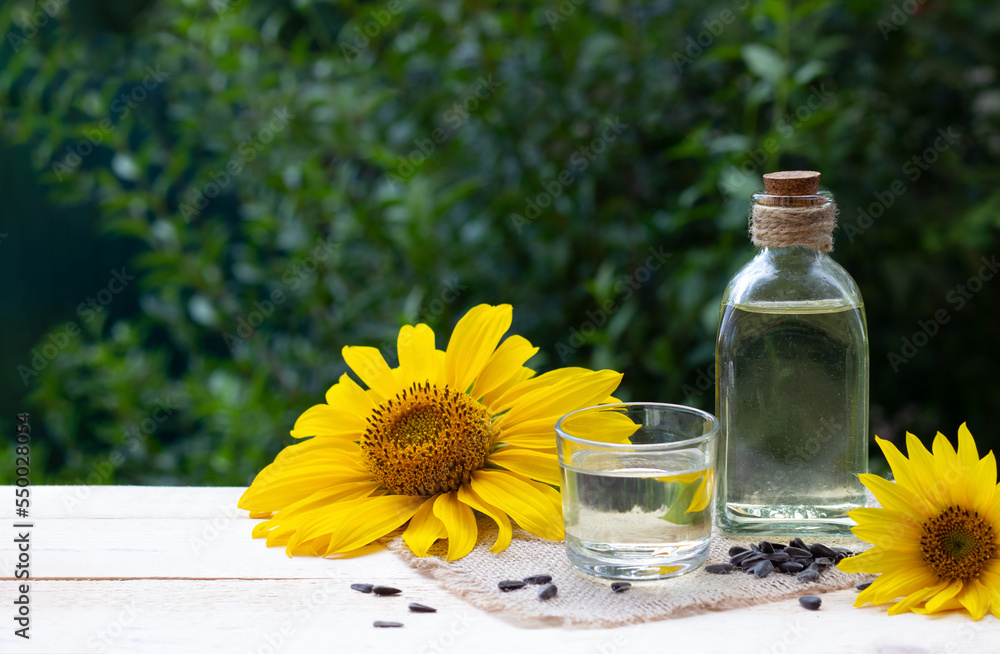 Close-up of sunflower oil in a bottle glass with seeds and sunflower Close-up of sunflower oil in a bottle glass with seeds and sunflower