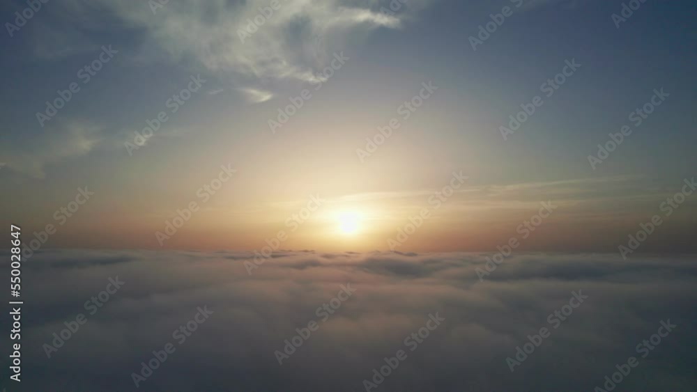 View from the cockpit of an airplane above the clouds at sunrise. View from the cockpit of an airplane above the clouds at sunrise.