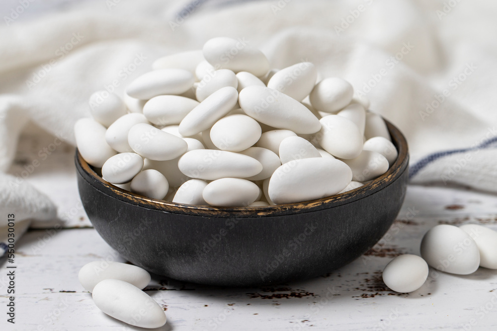 Almond candy. Sugared almonds on a white wood background. close-up . local name badem sekeri Almond candy. Sugared almonds on a white wood background. close-up . local name badem sekeri