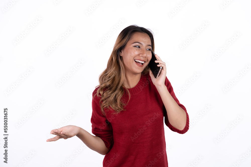 Portrait of an excited asian woman standing and using mobile phone isolated over white background. Portrait of an excited asian woman standing and using mobile phone isolated over white background.