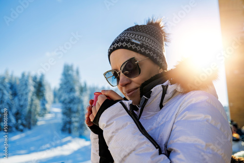 Girl drinking hot tea in the winter park