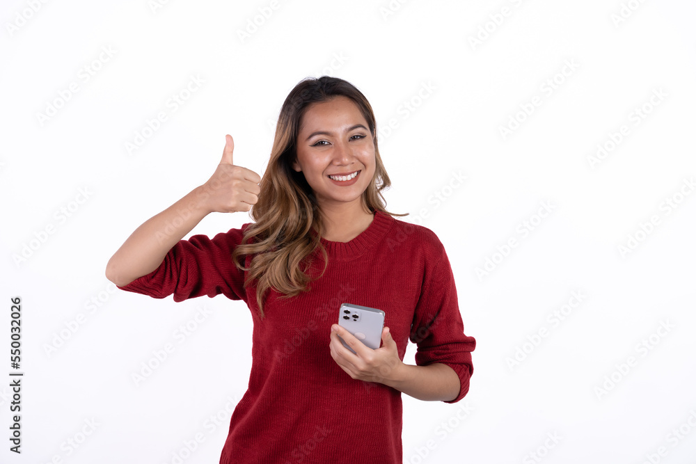 Portrait of an excited asian woman standing and using mobile phone isolated over white background. Portrait of an excited asian woman standing and using mobile phone isolated over white background.