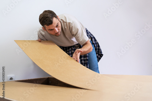 Man worker working with fiberboard. photo