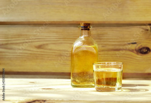 Vegetable oil in a bottle glass on the wooden background