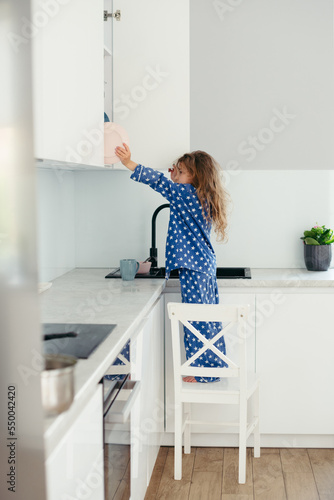 little girl in pajamas in the kitchen. happy morning concept © lavju83