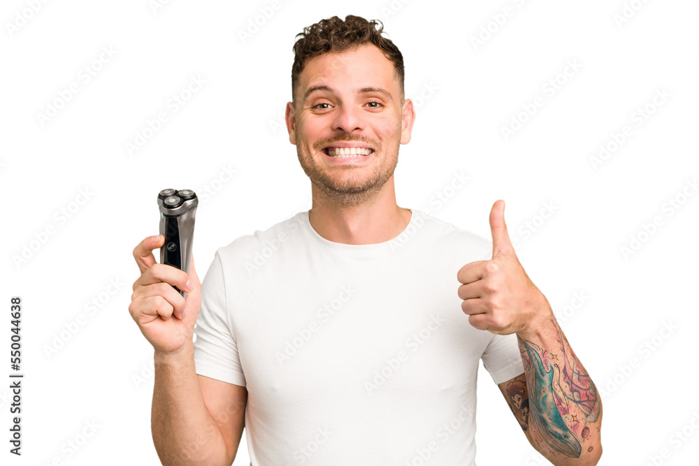 Young caucasian man holding a razor isolated smiling and raising thumb up