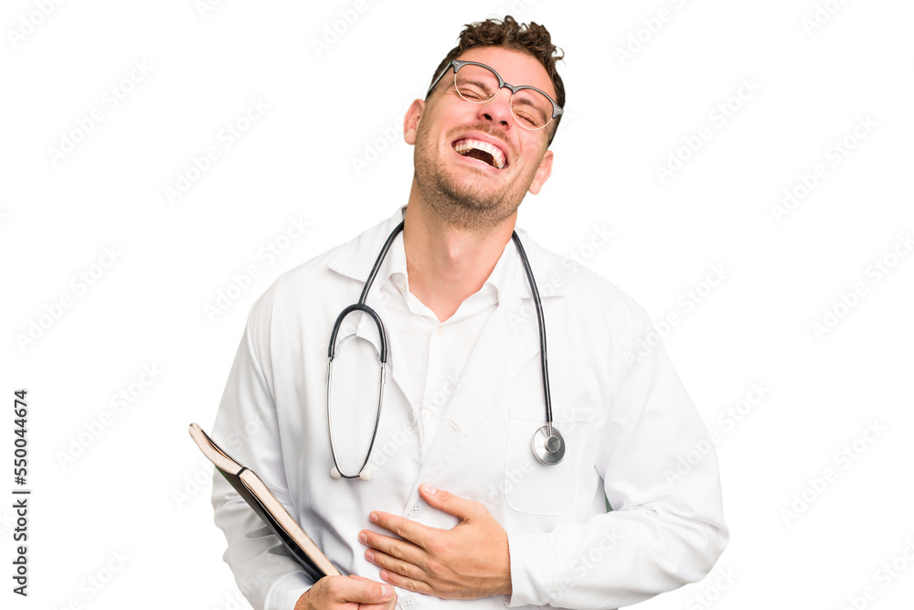 Young doctor caucasian man holding a book isolated laughing and having fun. Young doctor caucasian man holding a book isolated laughing and having fun.