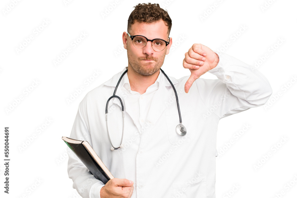 Young doctor caucasian man holding a book isolated showing a dislike gesture, thumbs down. Disagreement concept. Young doctor caucasian man holding a book isolated showing a dislike gesture, thumbs down. Disagreement concept.