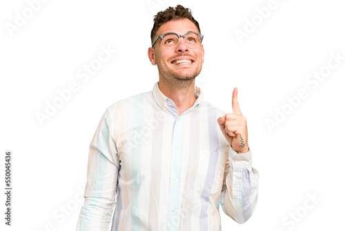 Young caucasian handsome man isolated indicates with both fore fingers up showing a blank space.