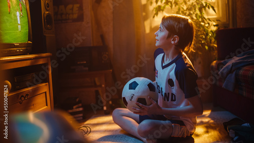 Young Excited Sports Fan Watches a Soccer Match on TV at Home. Boy Supporting His Favorite Football Team, Feeling Proud For Success of His Favourite Player. Nostalgic and Retro Childhood Concept.