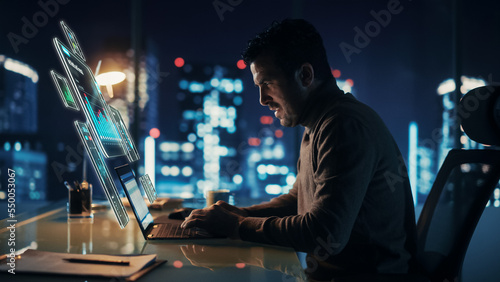 Executive Officer Working on Computer in Office at Night. Augmented Reality Corporate, Financial and Business App Icons Appear From Manager's Laptop. Internet and Productivity Concept.