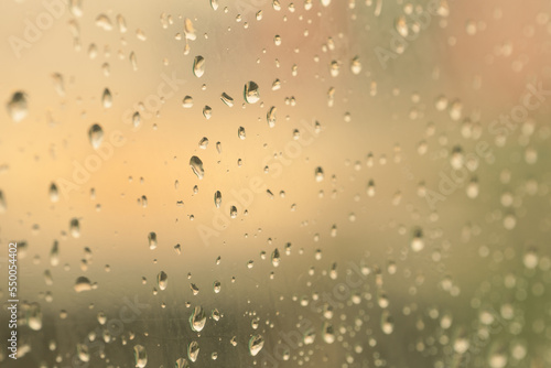 Raindrops on window glasses surface with road background .