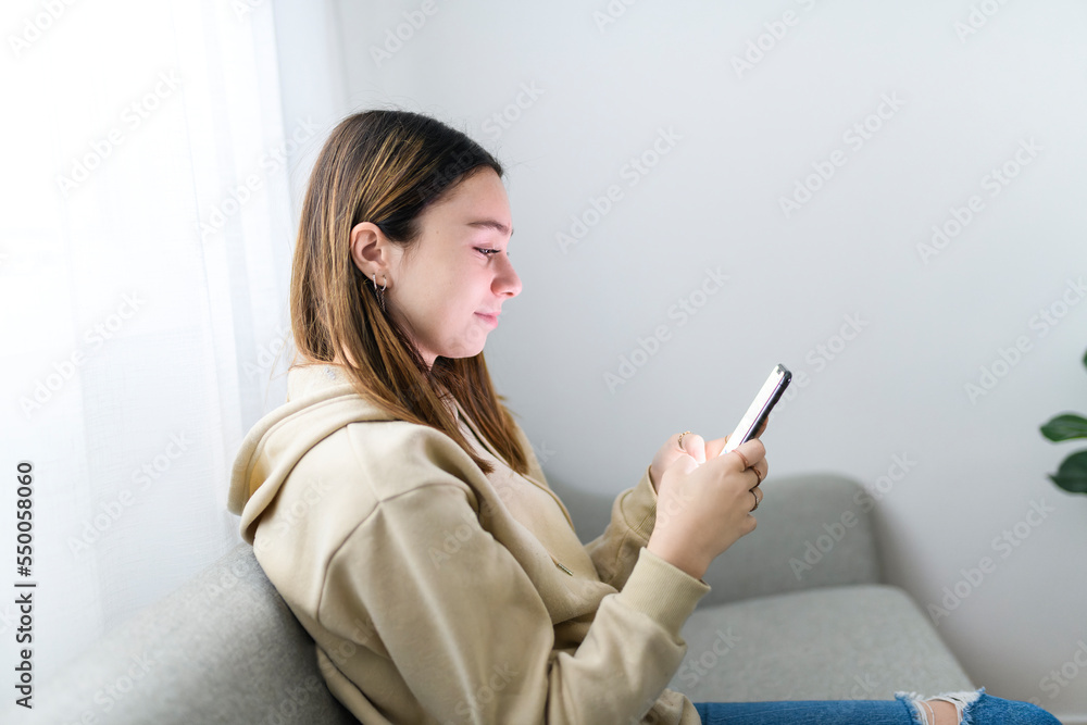 teen girl checking social media holding smartphone at home teen girl checking social media holding smartphone at home