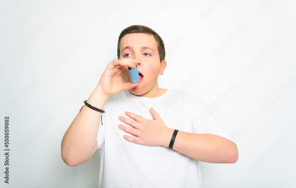 child using inhaler for asthma over White background studio child using inhaler for asthma over White background studio