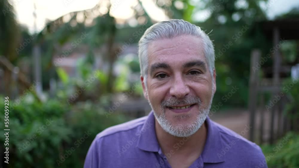 Happy portrait senior man face closeup looking at camera walking forward smiling Happy portrait senior man face closeup looking at camera walking forward smiling