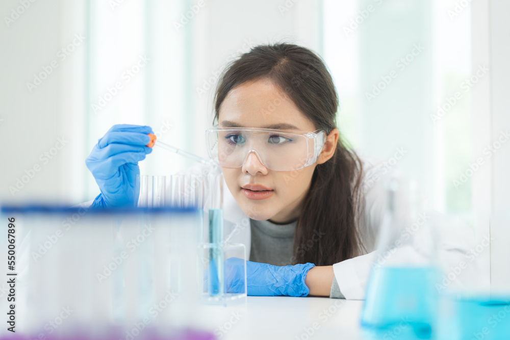 Medical development research laboratory, chemist or science woman scientist student in glass, glove looking pipette for test analysis liquid samples in clinic lab. Microbiology, analysing for medicine Medical development research laboratory, chemist or science woman scientist student in glass, glove looking pipette for test analysis liquid samples in clinic lab. Microbiology, analysing for medicine