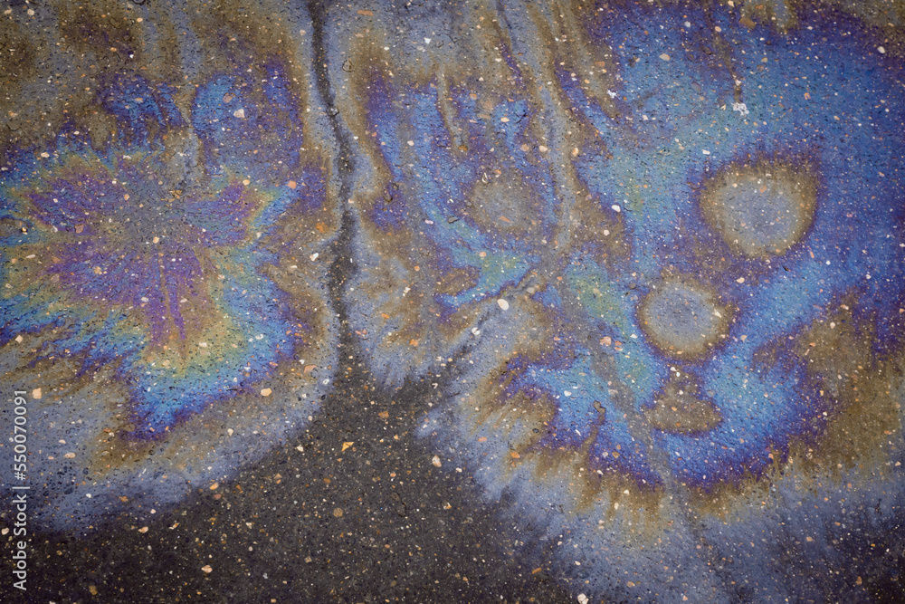 Oil rainbow gasoline spill on asphalt. Environmental pollution conceptGasoline flows on the asphalt. Rainbow stains of oil and gasoline. Oil rainbow gasoline spill on asphalt. Environmental pollution conceptGasoline flows on the asphalt. Rainbow stains of oil and gasoline.