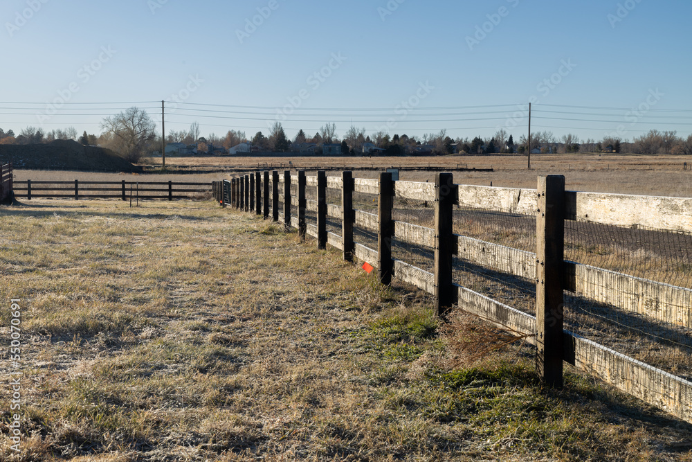 Looking down the wooden fence of a farm