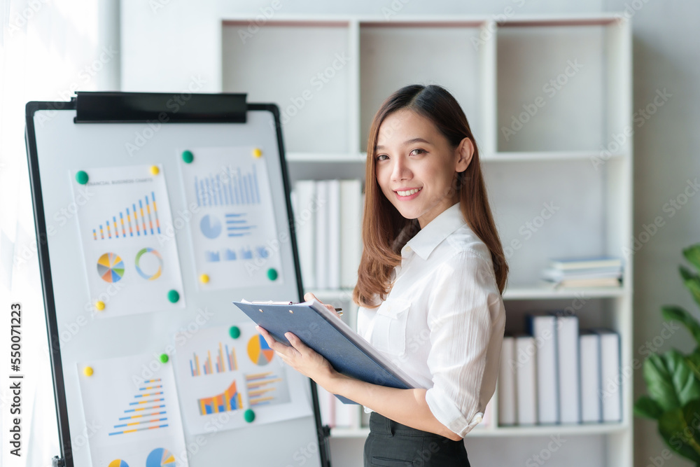 Happy beautiful Asian businesswoman smiling and enjoying working in office and looking at camera. Happy beautiful Asian businesswoman smiling and enjoying working in office and looking at camera.