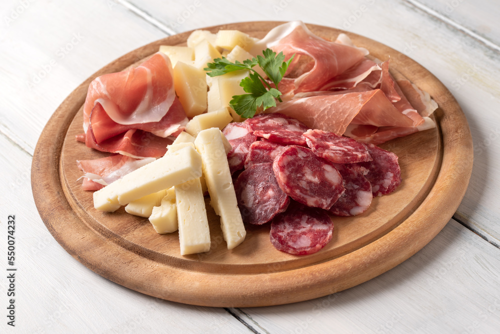 Tagliere di cibi italiani: prosciutto crudo, culatello, pecorino fresco e salame 