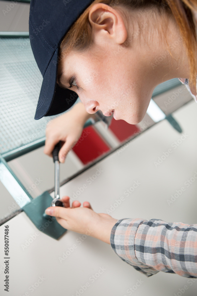 female construction worker fixing a nail