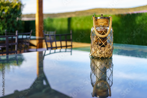 Glass jar with stones on top of a rustic country house table.