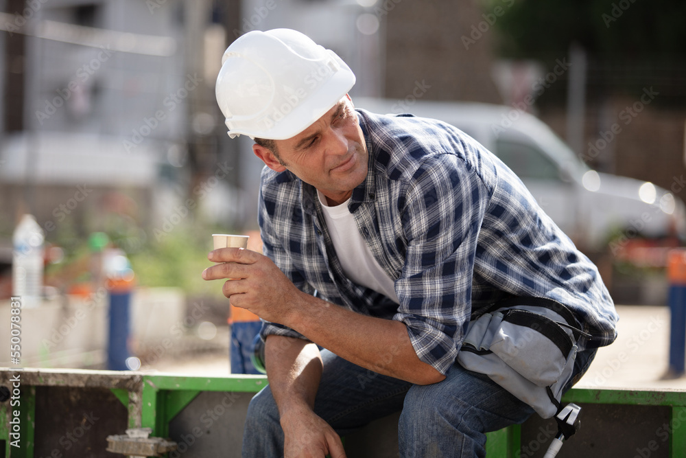 happy mid adult construction worker taking a break happy mid adult construction worker taking a break