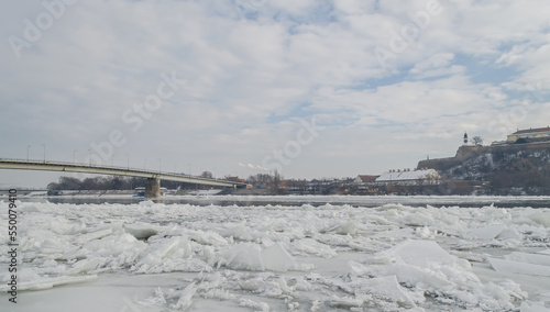 The bank of the Danube river covered with snow. Danube River covered with snow and ice. Frozen and snow-covered waterway of Danube river below Petrovaradin fortress  Vojvodina  Novi Sad  Petrovaradin 