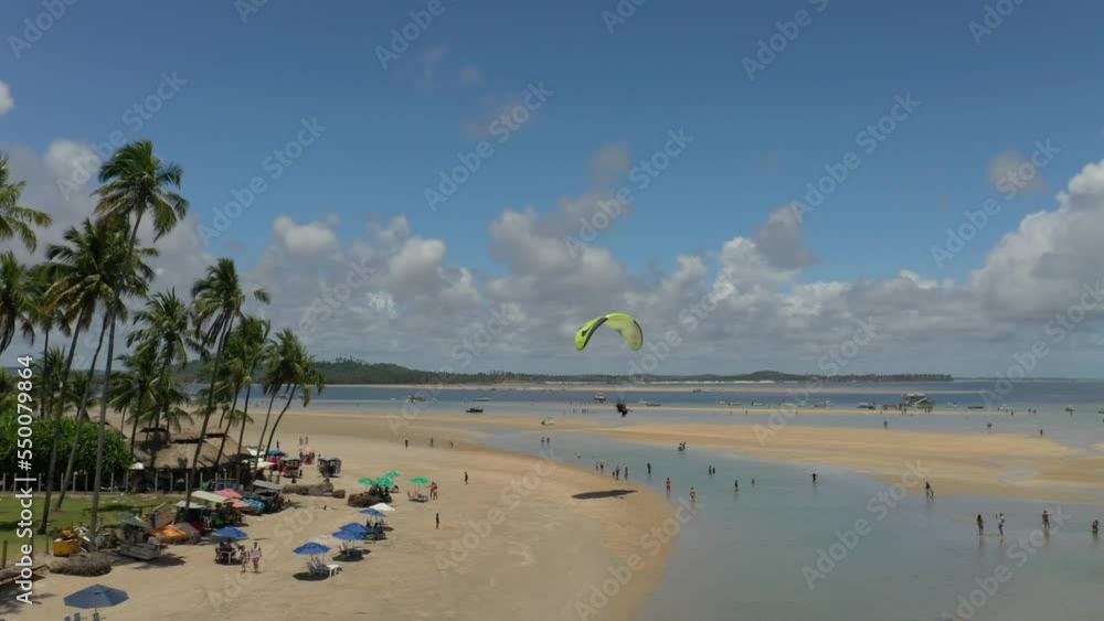 motorized paraglider flying low over the beach sand in Porto de Galinhas