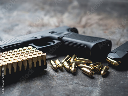Fototapeta Hand gun with ammunition on dark background