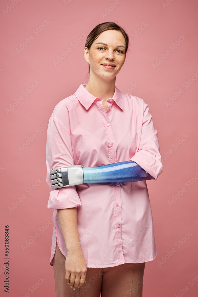 Portrait of positive young woman with bionic hand smiling at camera Portrait of positive young woman with bionic hand smiling at camera