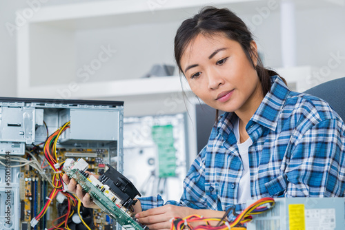 female computer engineer repairing computer motherboard