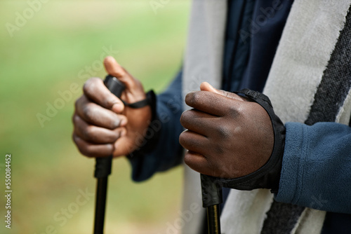 Closeup of male hands holding walking poles during hike in nature