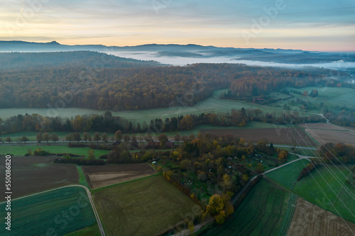 Aerial view of allotment garden from above. Landscape with fog over river valley in autumn. Germany, Nurtingen, Swabian alb. photo