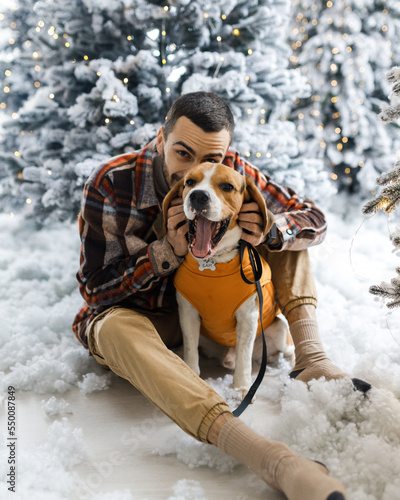 Cute New Year's photo of a man and his dog. Portrait festive photos of a dog in New Year's decorations.