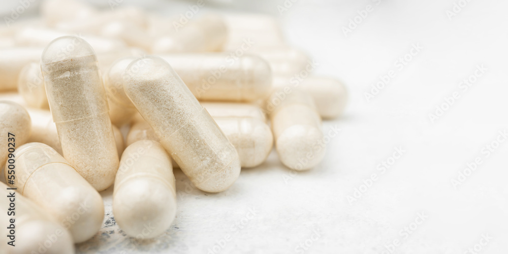 White medicine capsules, vitamin pills or drugs, medication treatment, health care concept White medicine capsules, vitamin pills or drugs, medication treatment, health care concept