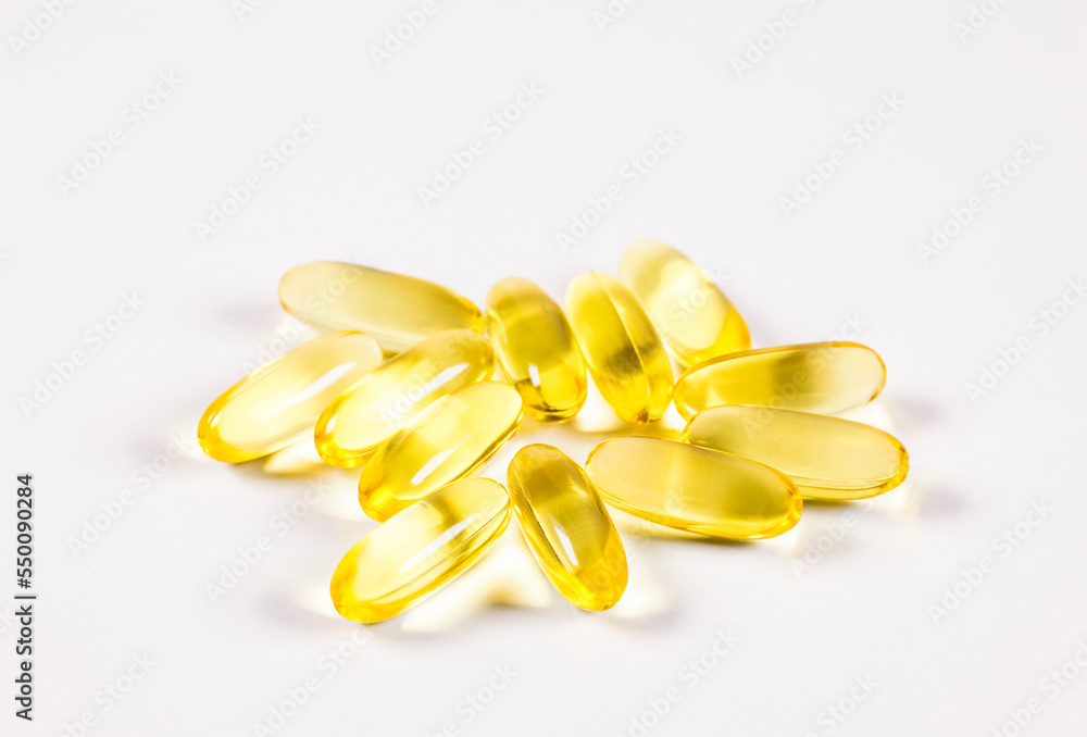 Yellow scattered pills on white background. Сapsules on white background. Yellow scattered pills on white background. Сapsules on white background.
